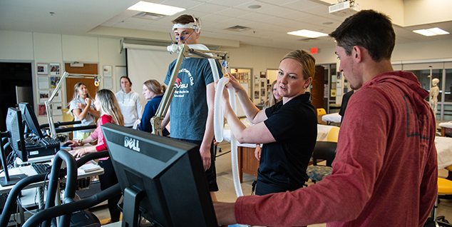 Students watching another student on a treadmill